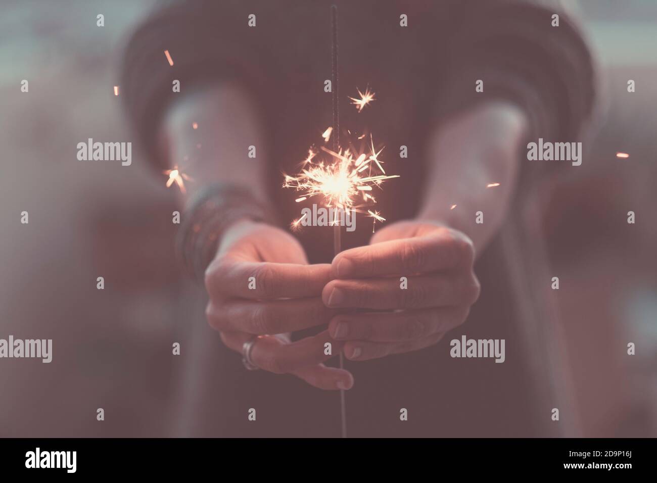 Romantic love concept of life with close up of hands with fire sparklers by night to celebrate - romance and party event time Stock Photo