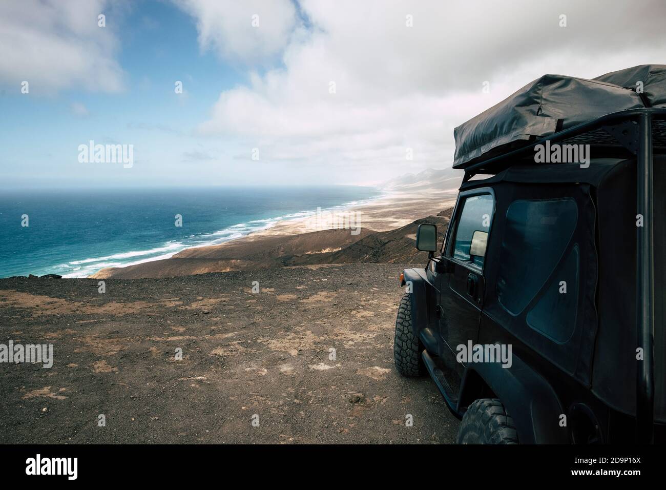 Black off road car parked on the top of a valley with amazing view on a wild beach with nobody - off grid roof tent and adventure lifestyle travel concept Stock Photo