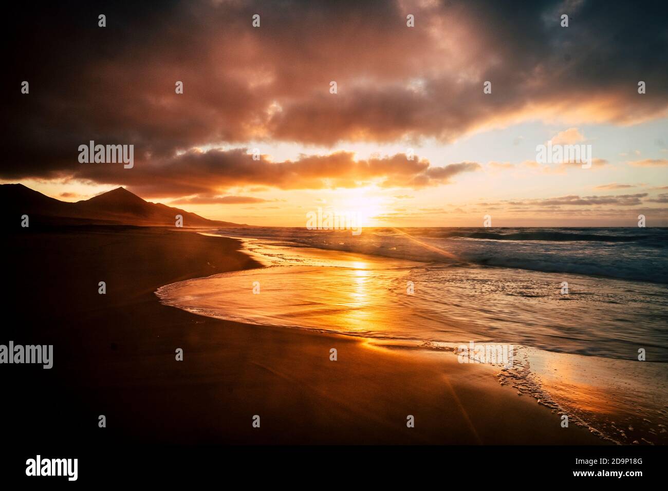 Wonderful timeless sunset at the beach with dramatic clouds and waves ...