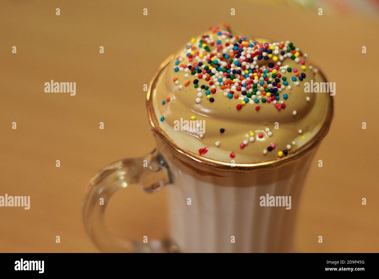 Dalgona Coffee in Glass Mug with Rainbow sprinkles Stock Photo