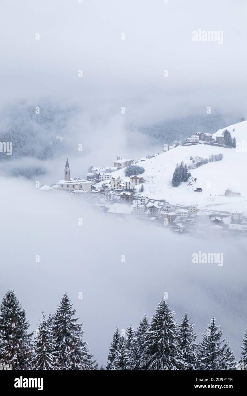 the villages of candid and casamazzagno emerging from the winter mists, dolomites, comelico superiore, belluno, veneto, italy, europe Stock Photo