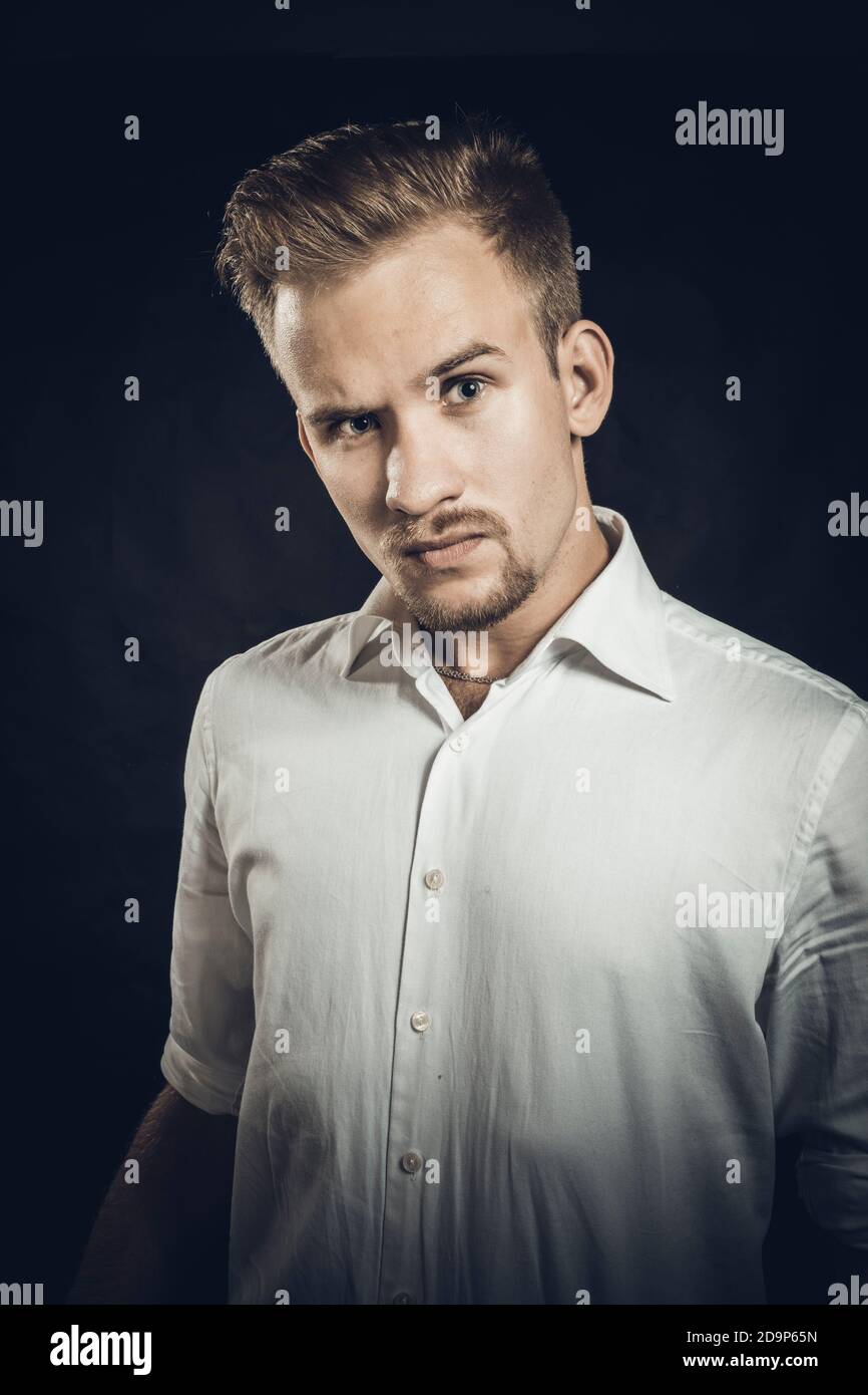 Young man dressed in white shirt studio emotional portrait Stock Photo ...