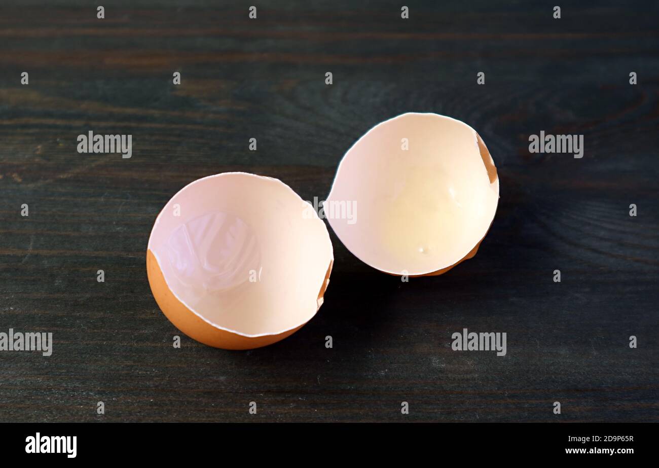 Cracked eggshells isolated on black wooden table Stock Photo