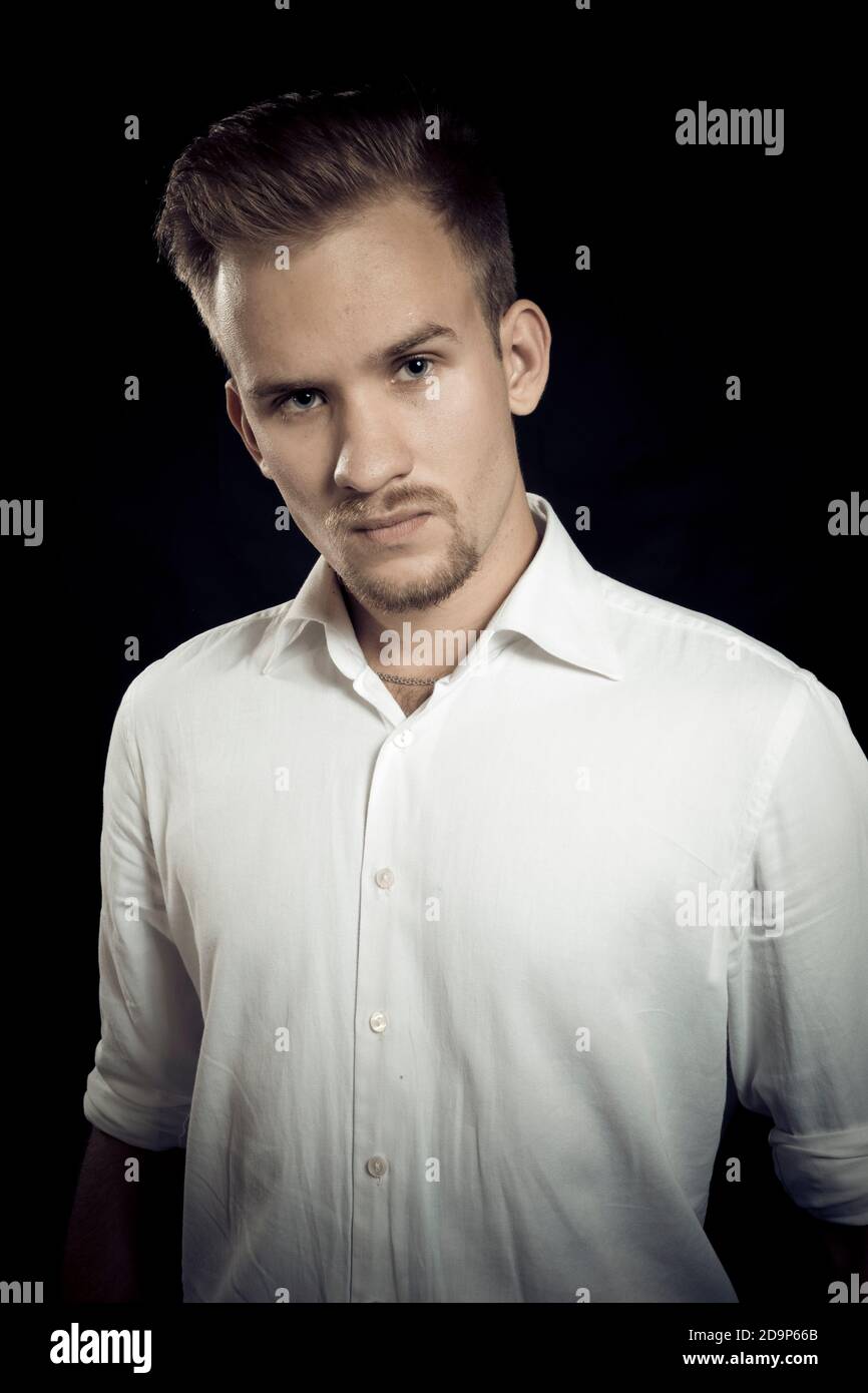 Young man dressed in white shirt studio emotional portrait Stock Photo ...