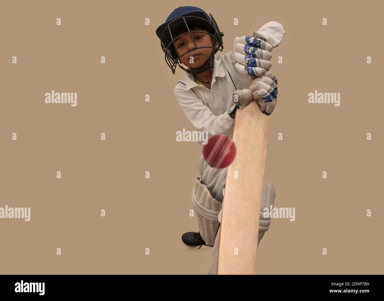 A boy in cricket uniform playing Cricket Stock Photo Alamy