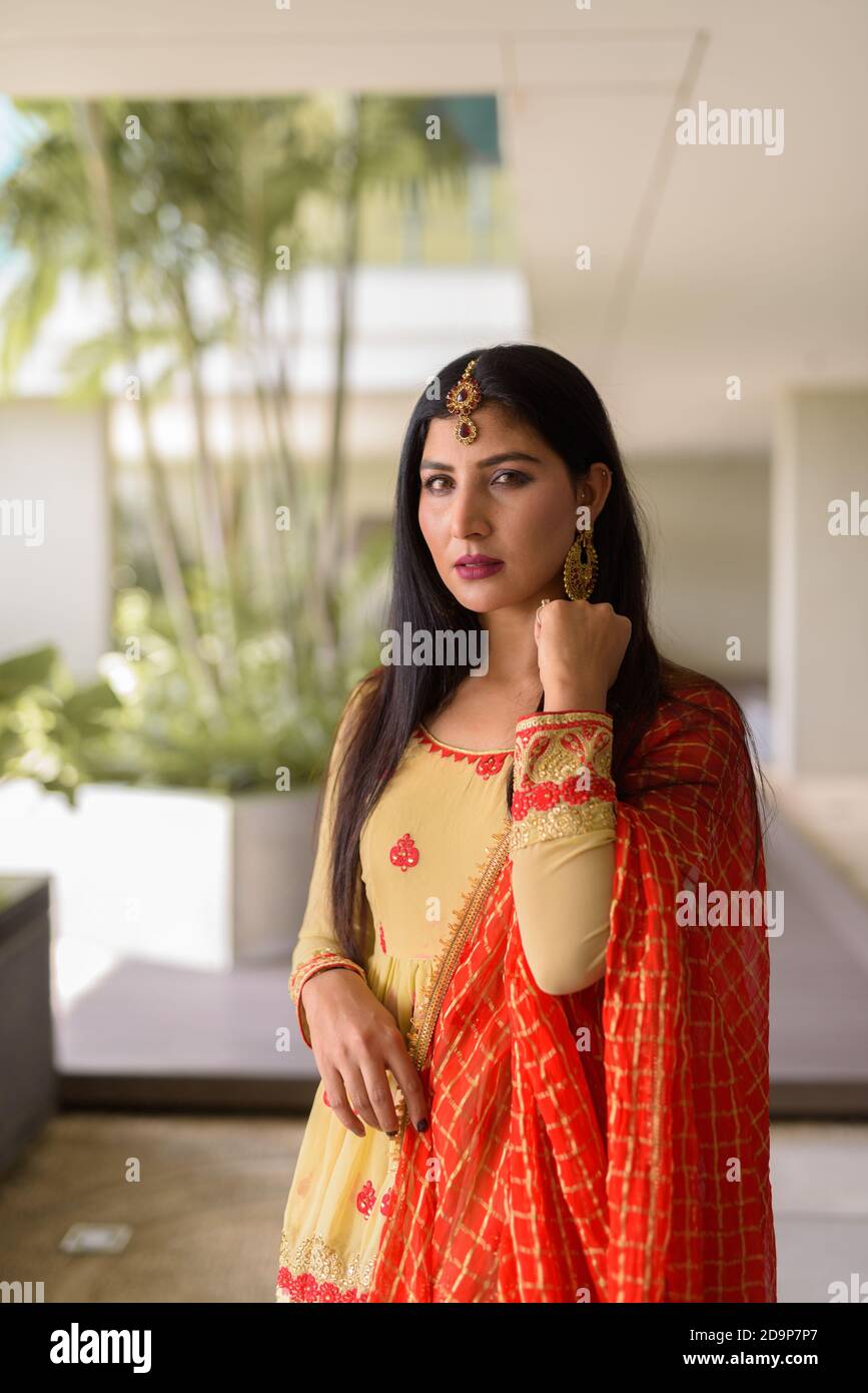 Portrait of beautiful young woman wearing traditional Indian dress ...