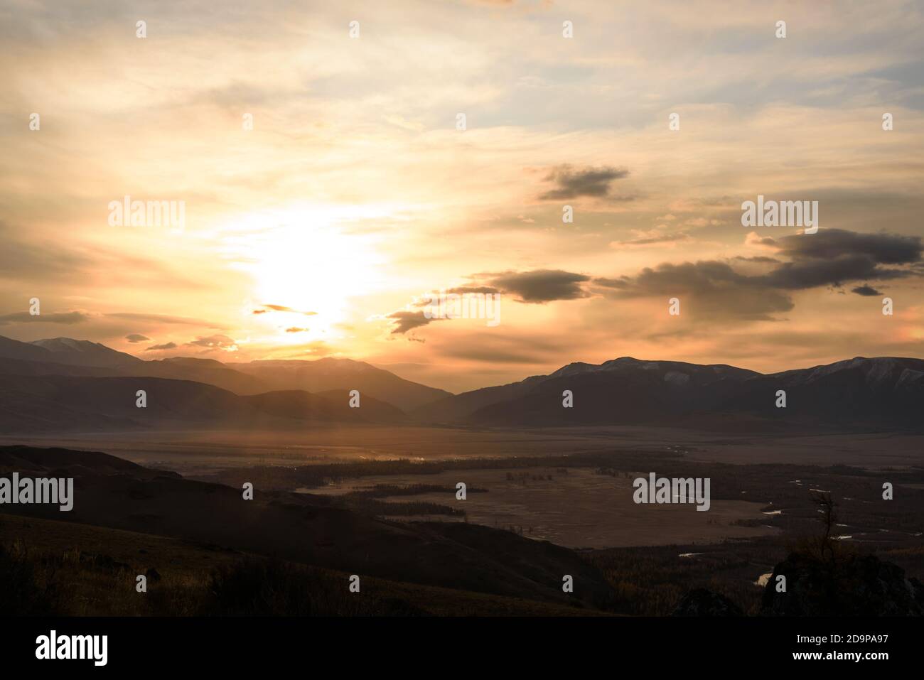 Colorful golden sunrise with sun and clouds on the sky over mountains ...
