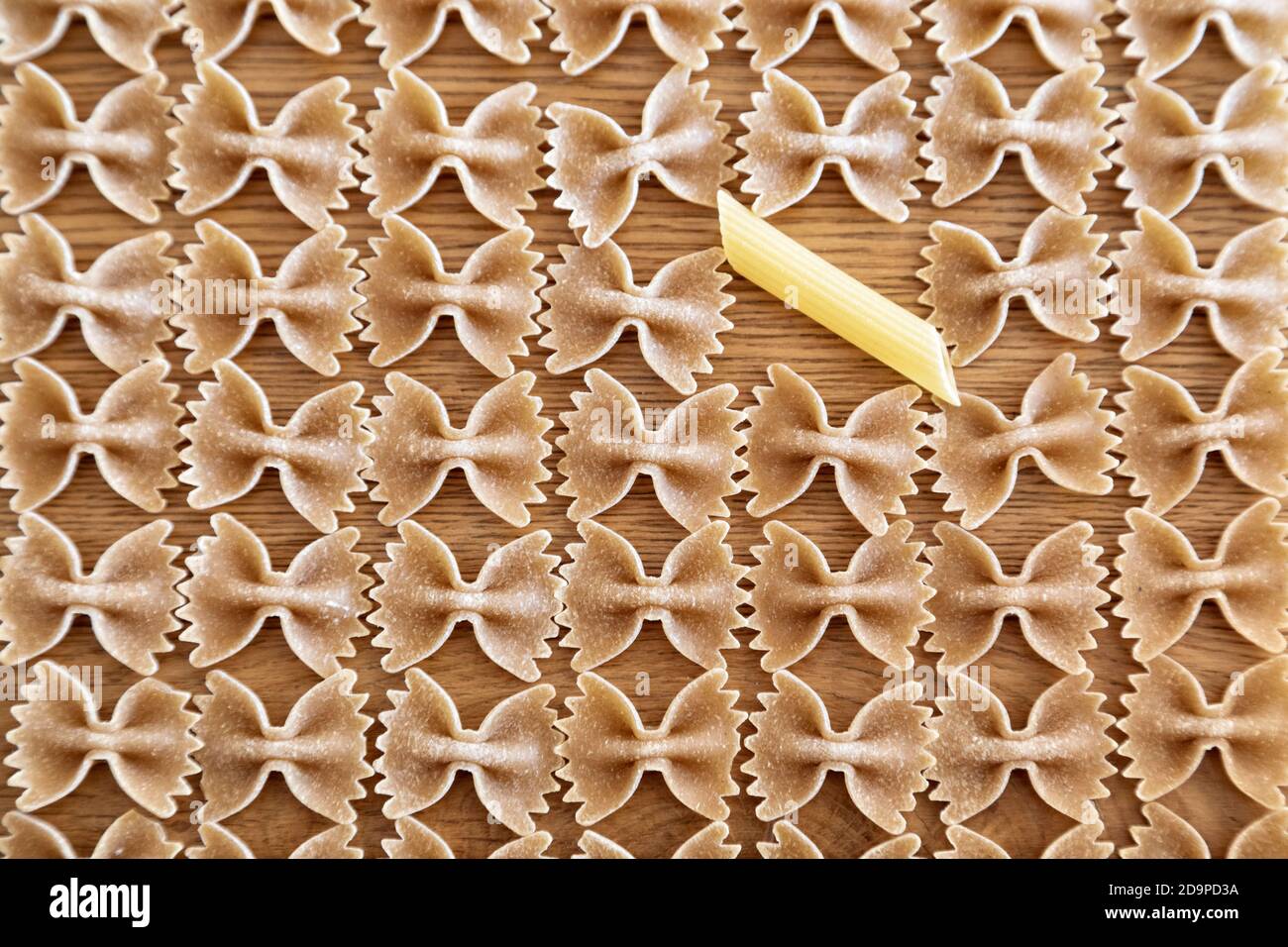 composition of durum wheat pasta, farfalle shape, repeated elements, abstract background Stock Photo