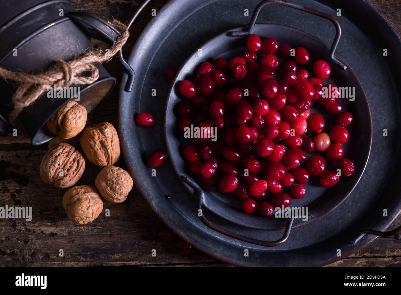 Antique dish and rustic jar filled with fresh cranberries and walnuts for thanksgiving Stock Photo