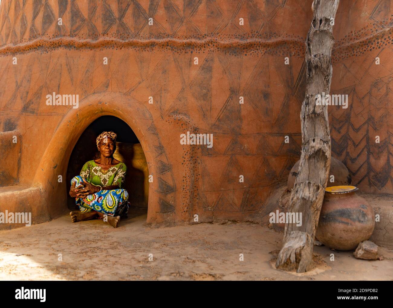 Old woman sitting at the entrance of her colorful house Stock Photo - Alamy