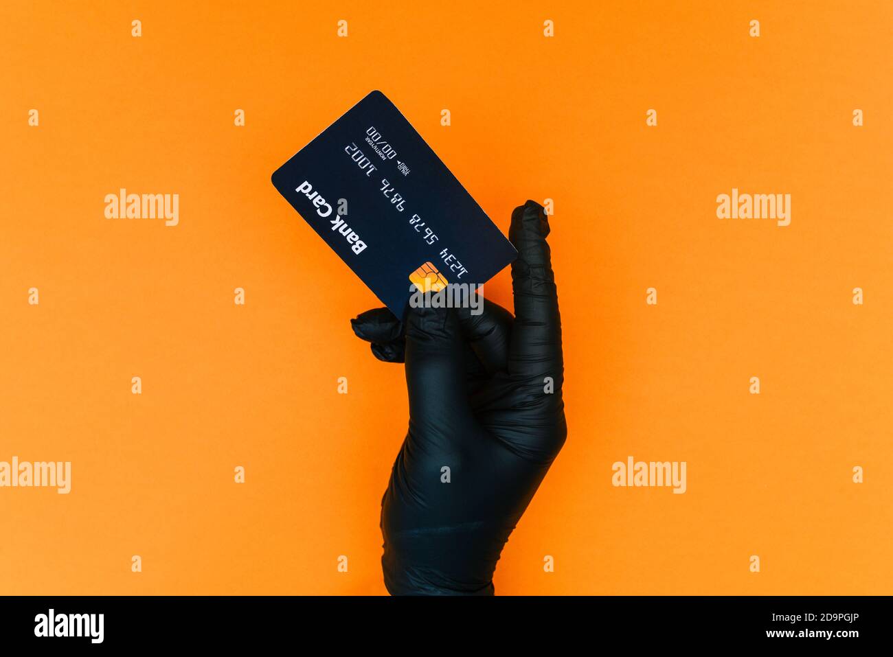 Hand in a disposable black glove with a bank card. Contactless payment of the invoice for purchases by the client during covid-19. Sale, prevention of Stock Photo
