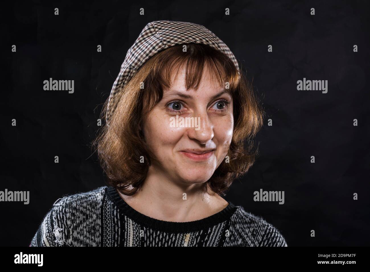 Cheerful 40 years old woman dressed in jeans and poncho studio portrait