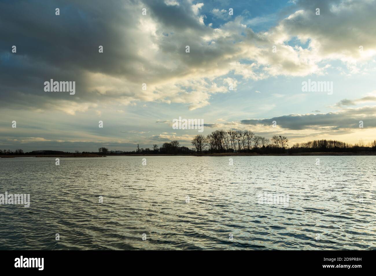 Evening clouds in the sky over a peaceful lake Stock Photo