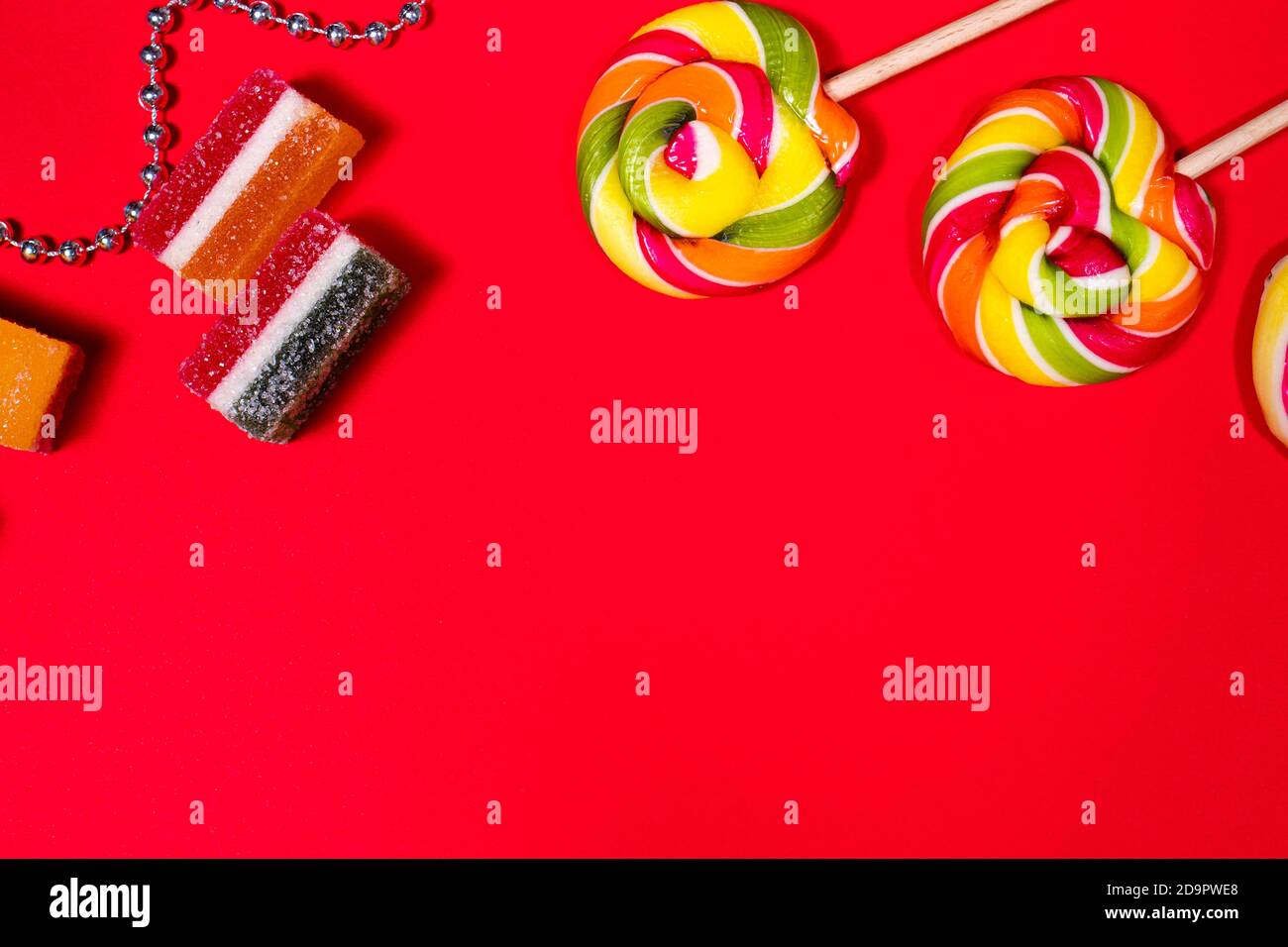 Candy, lollipops, multi-colored marmalade on a red background with a place for text layout Stock Photo