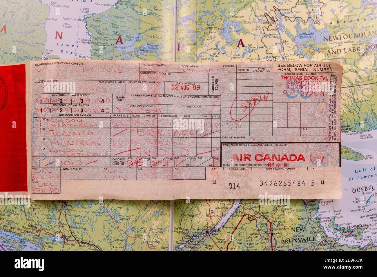 A hand written IATA plane ticket issued by Thomas Cook Travel from 1989 (for flights between the UK and Canada) on a map of Canada. Stock Photo