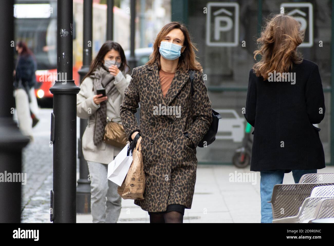 Beautiful girl or woman wearing mask and walking in the city for shopping during Covid or Coronavirus outbreak Stock Photo