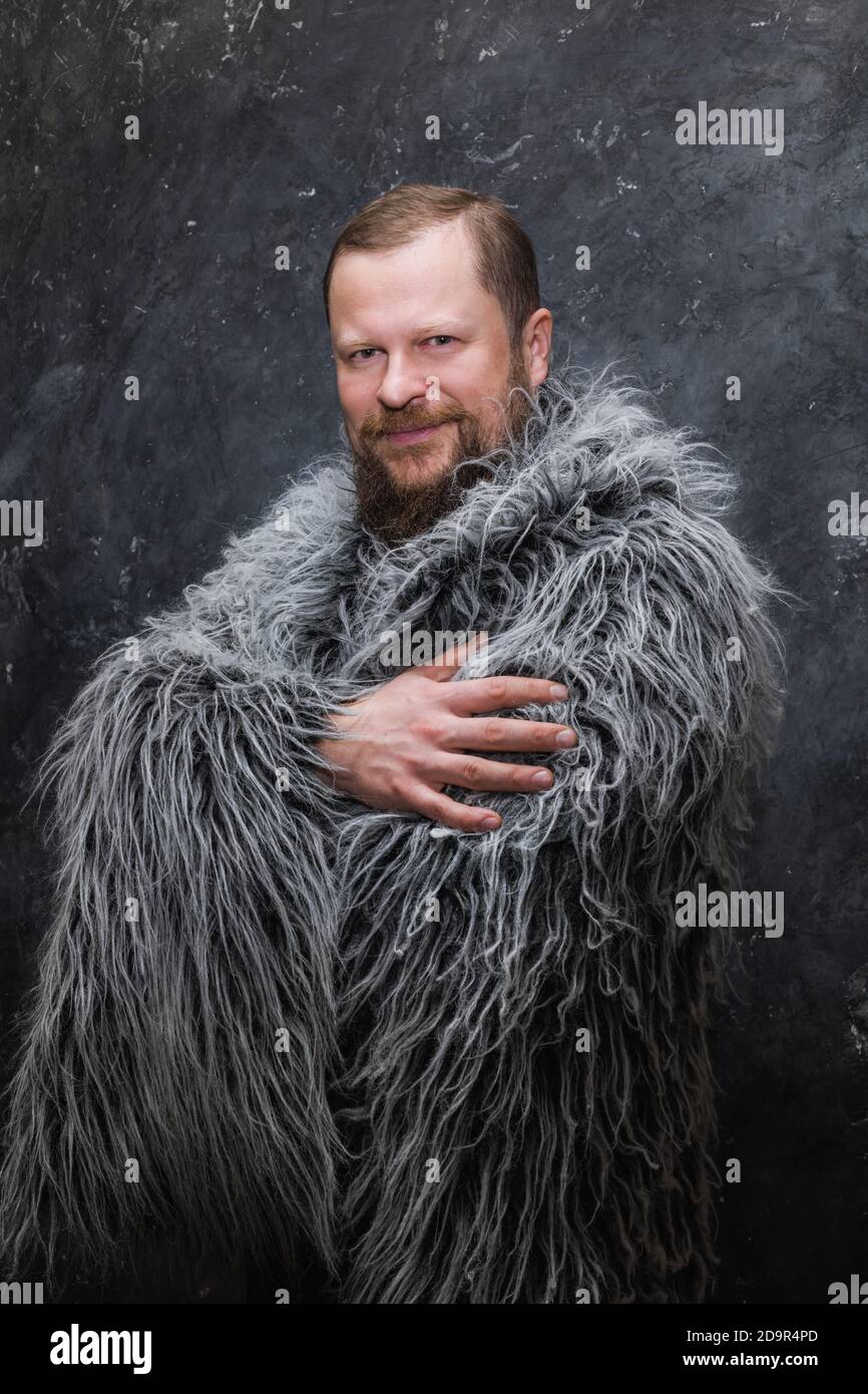 Solid bearded man in a fur skin studio portrait Stock Photo - Alamy