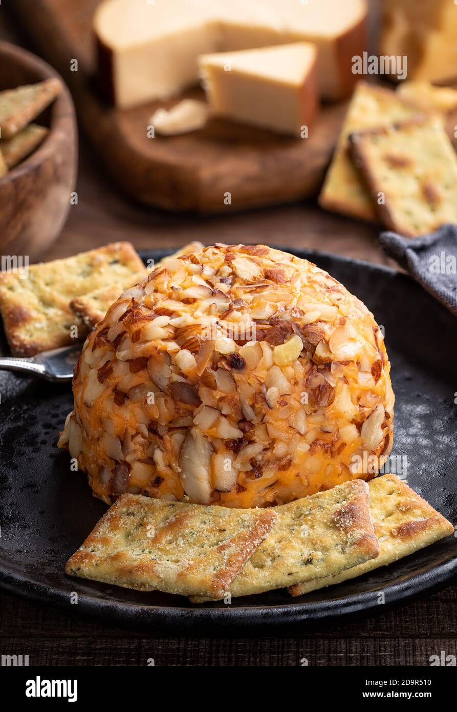 Closeup of a cheddar cheese ball and crackers on a plate Stock Photo