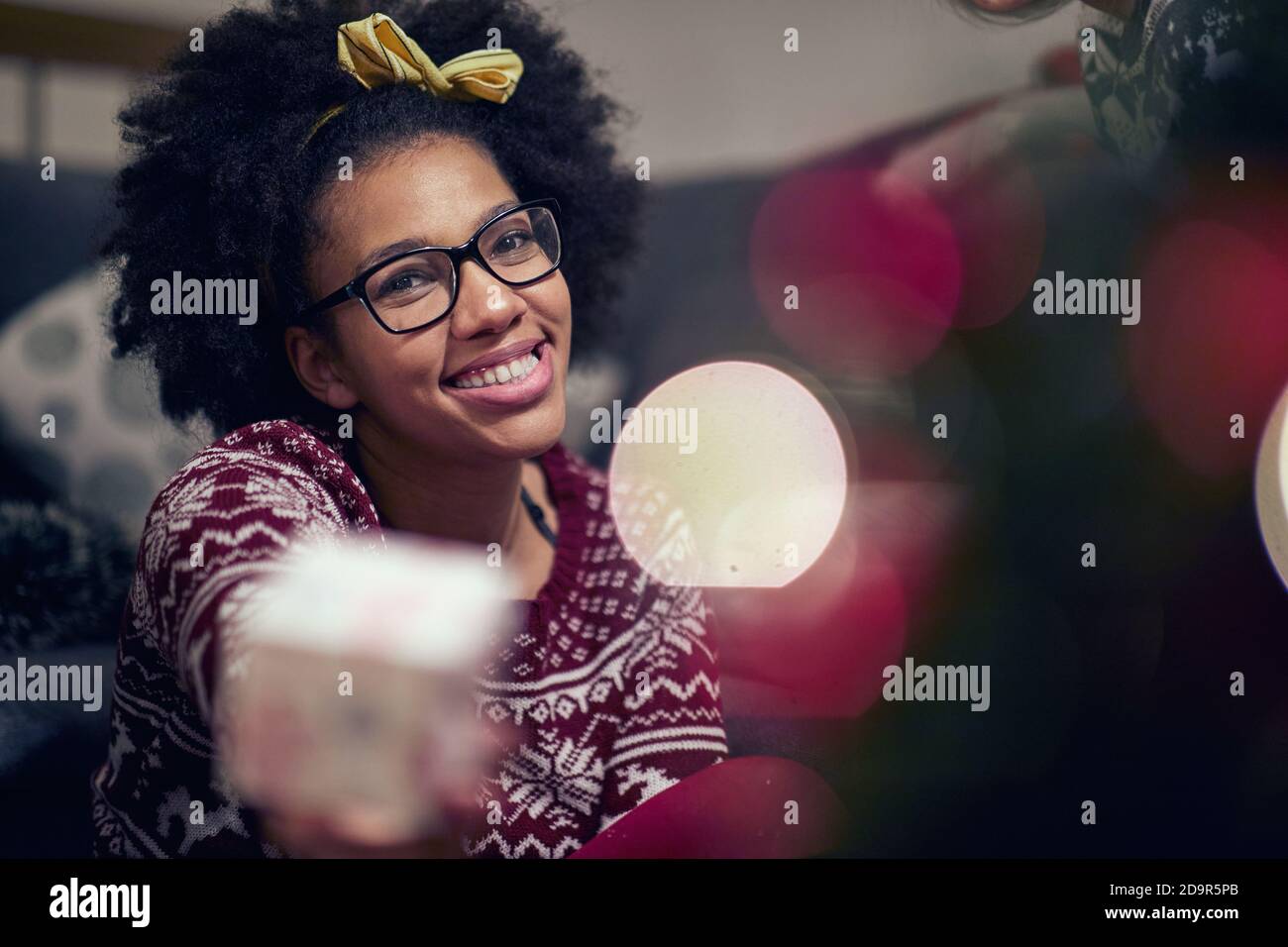 Cheerful afro american teenage girl reciving xmas gift; Happy family moments concept Stock Photo