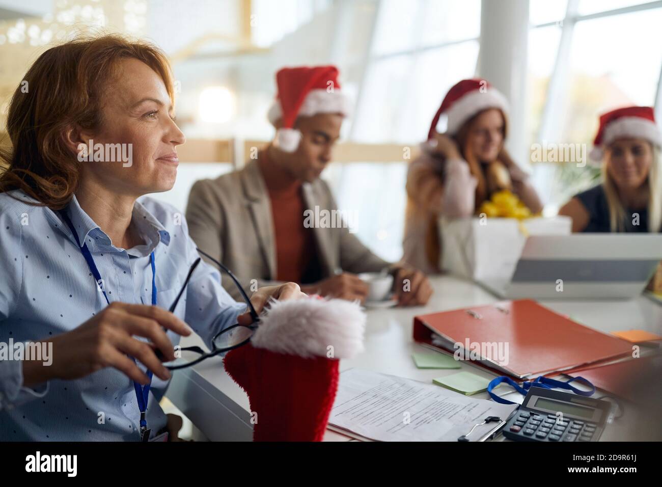 christmastime in the bright lighted office. boss with employees having a good time Stock Photo