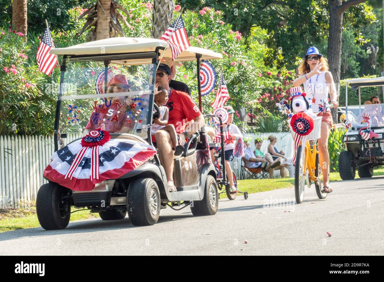 Decorated golf cart floats and bicycles ride down the road during the annual Independence Day parade July 4, 2019 in Sullivan's Island, South Carolina. The tiny affluent Sea Island beach community across from Charleston holds an outsized golf cart parade featuring more than 75 decorated carts. Stock Photo