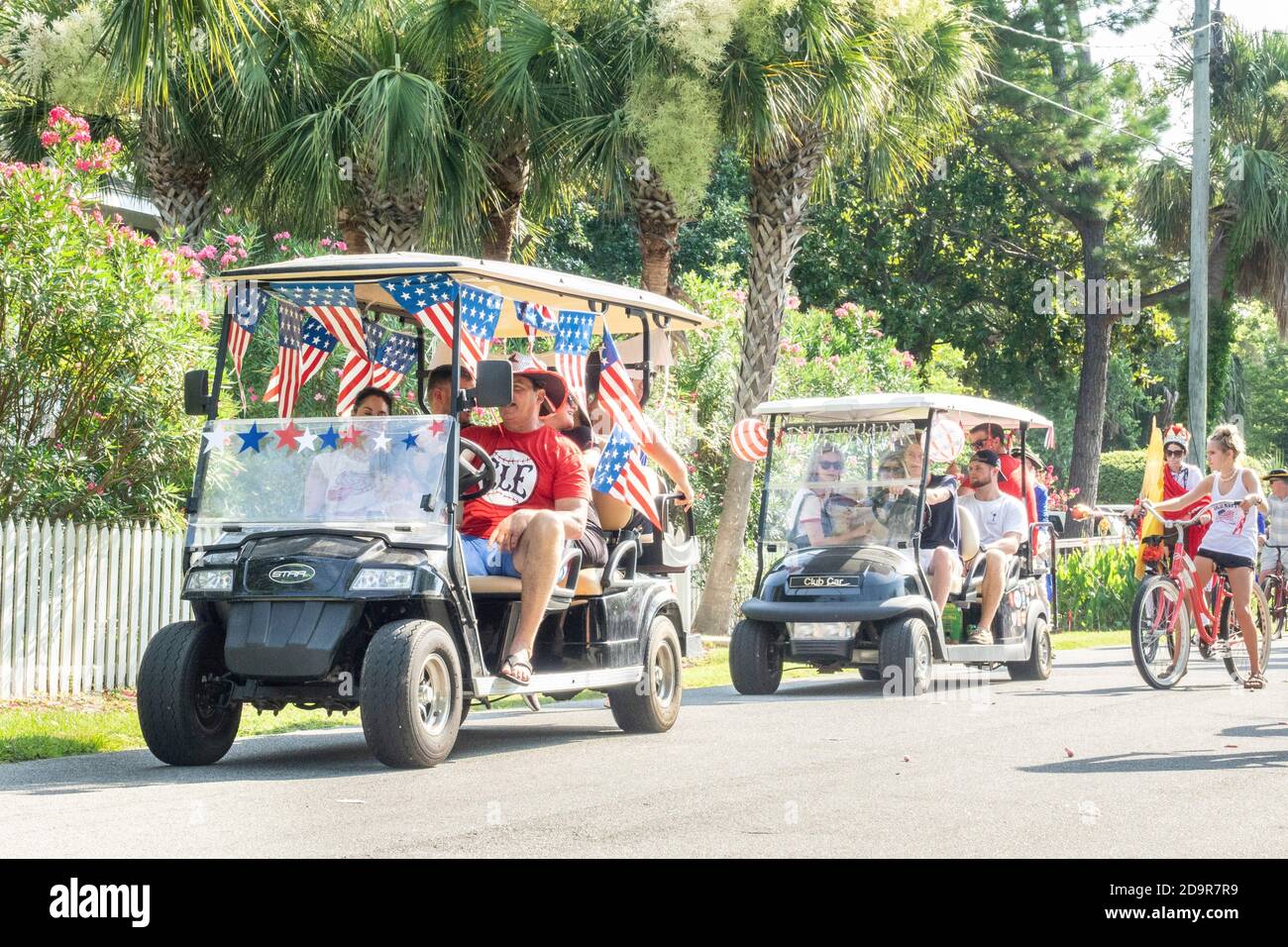 Decorated golf carts ride down the road during the annual Independence Day parade July 4, 2019 in Sullivan's Island, South Carolina. The tiny affluent Sea Island beach community across from Charleston holds an outsized golf cart parade featuring more than 75 decorated carts. Stock Photo