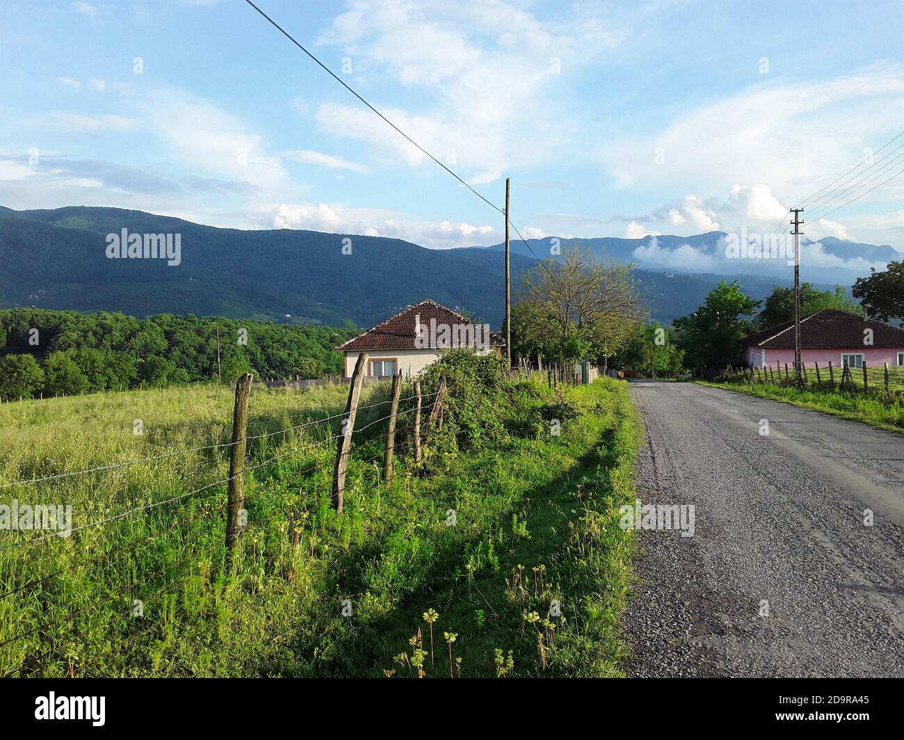 Green mountains, clouds, meadows, village houses and a broken wooden fence. A view from Hendek/Sakarya. Stock Photo