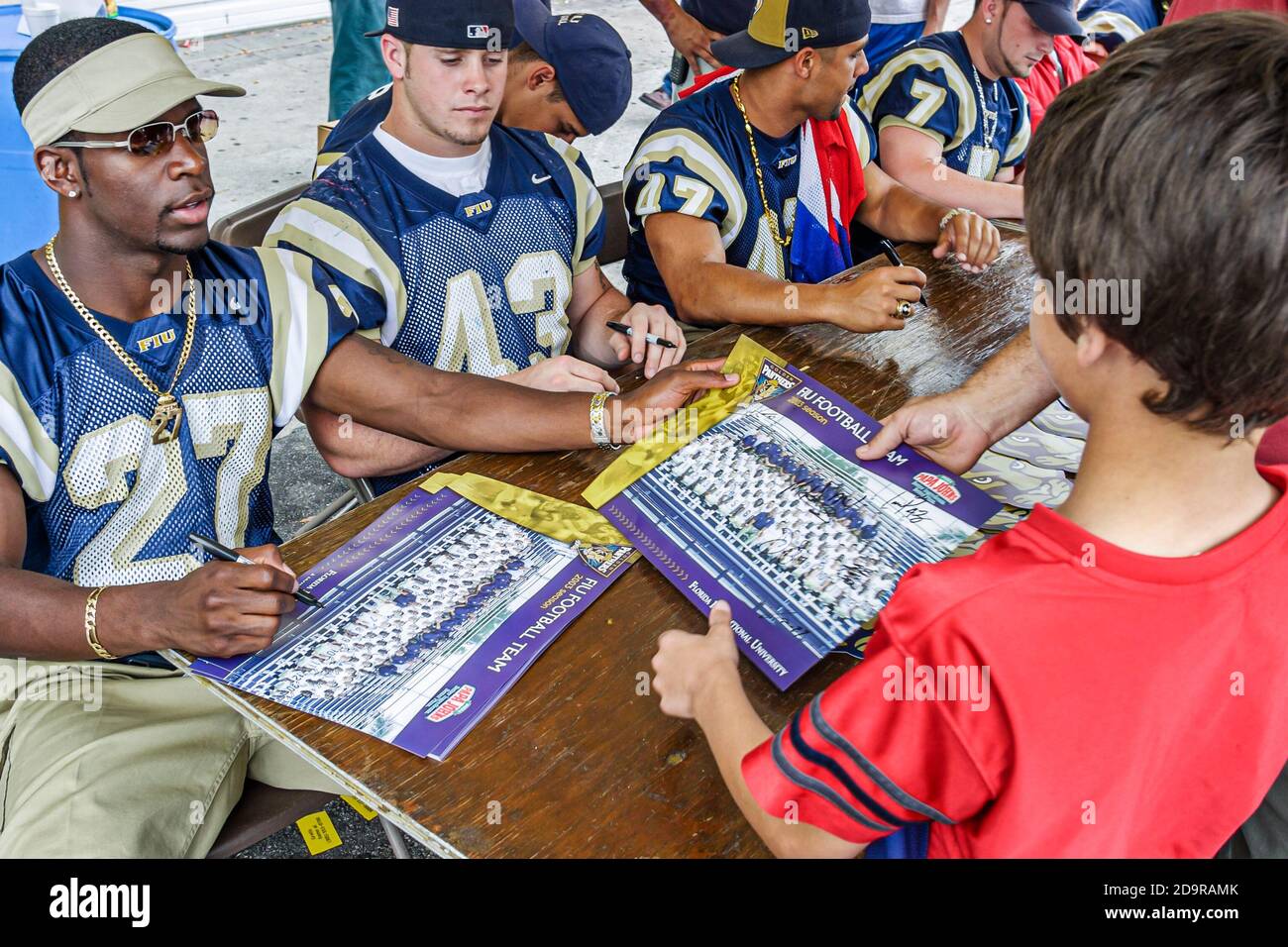 Miami Florida,Little Havana,Calle Ocho Festival,annual event FIU football players signing autographs,Black African man male student, Stock Photo