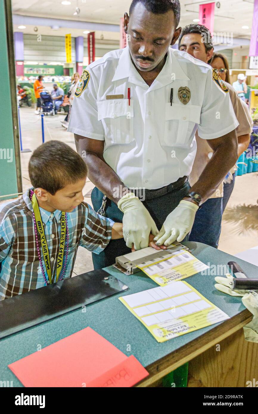 Miami Florida,Dade County Fair & Exposition,annual event youth programs exhibits Corrections & Rehabilitation Department,fingerprinting Hispanic boy B Stock Photo