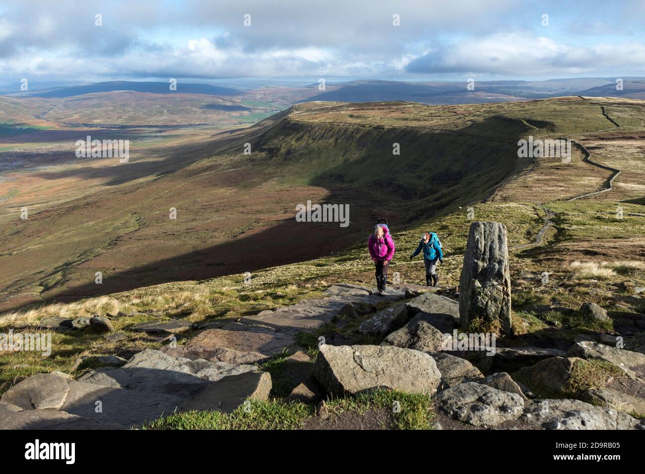 Walkers Heading Towards the Summit of Ingleborough with the View Towards Ribblehead and Simon Fell, Yorkshire Dales, UK Stock Photo
