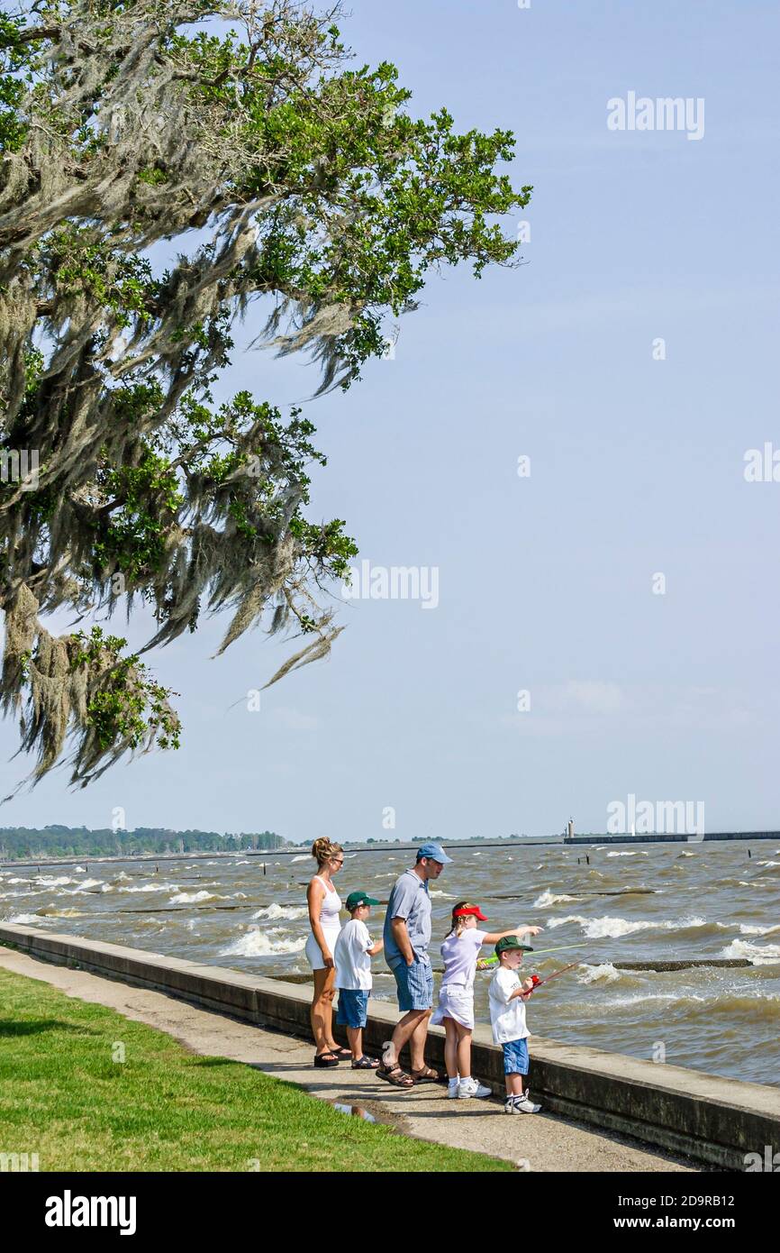 Louisiana Lake Pontchartrain Northshore,Mandeville Lakeshore Drive,child children boy boys girl sister brothers siblings fish fishing,mother father fa Stock Photo