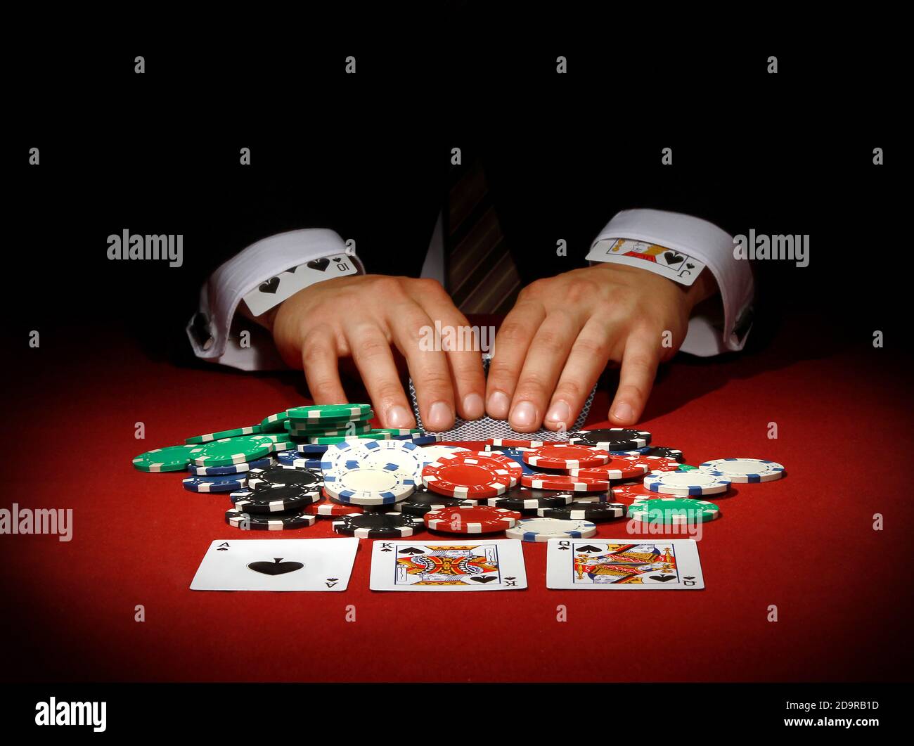Closeup of male hands playing poker with cards in shirt sleeves - concept of cheating Stock Photo