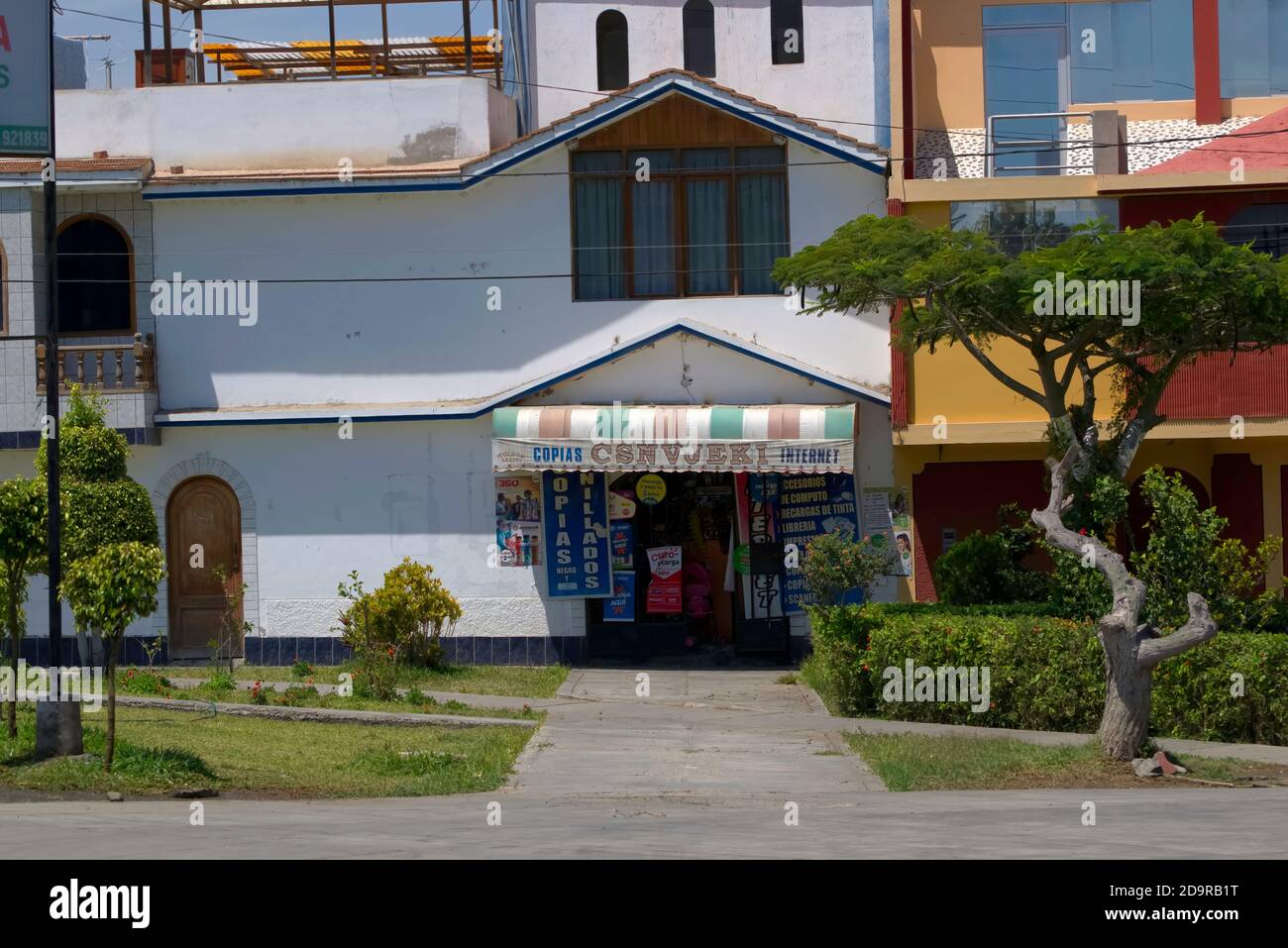 New Chimbote, Peru - April 18, 2018: Front of shop indicating photocopy and internet services with pavement and grass to foreground Stock Photo