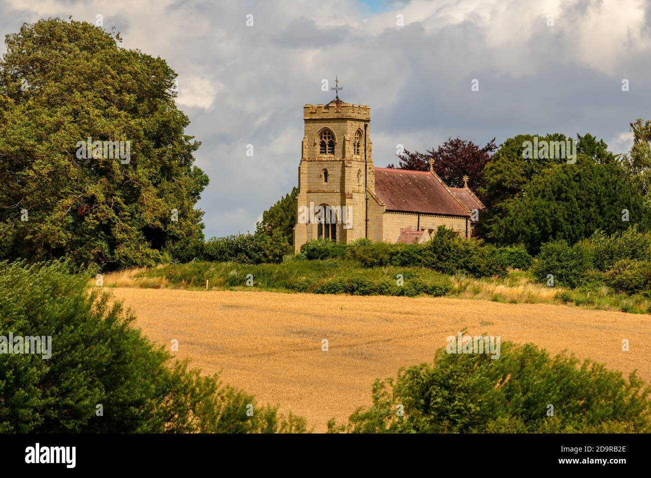 English stone church at Uppington Shropshire seen over cornfield Stock Photo