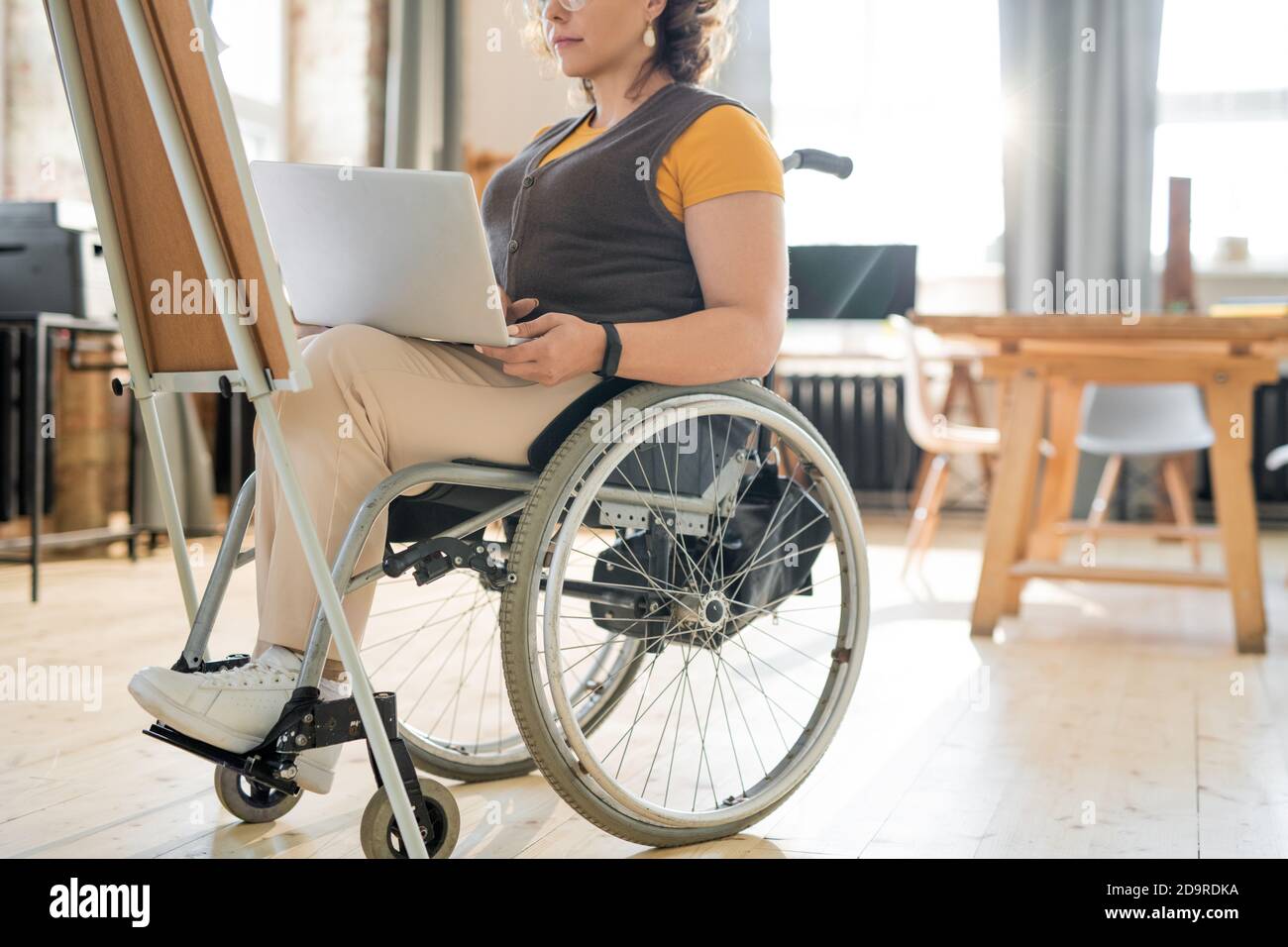 Young businesswoman in wheelchair using laptop while preparing presentation Stock Photo