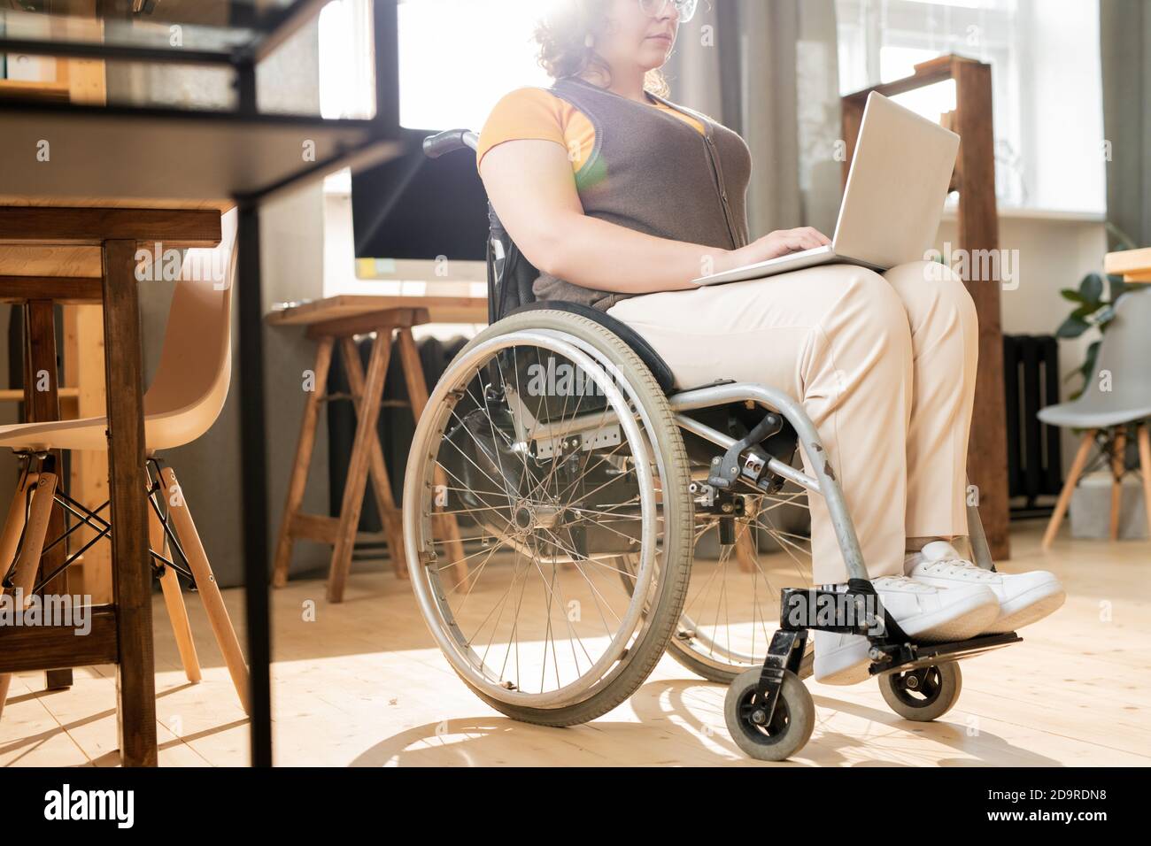 Young disable female office worker looking through text on laptop display Stock Photo