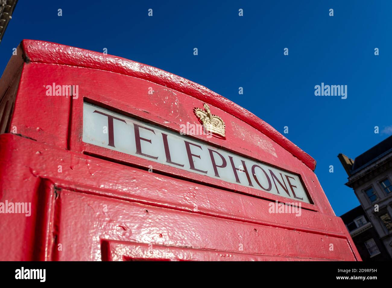 Detail of a red London telephone box. Red phone box lettering and royal