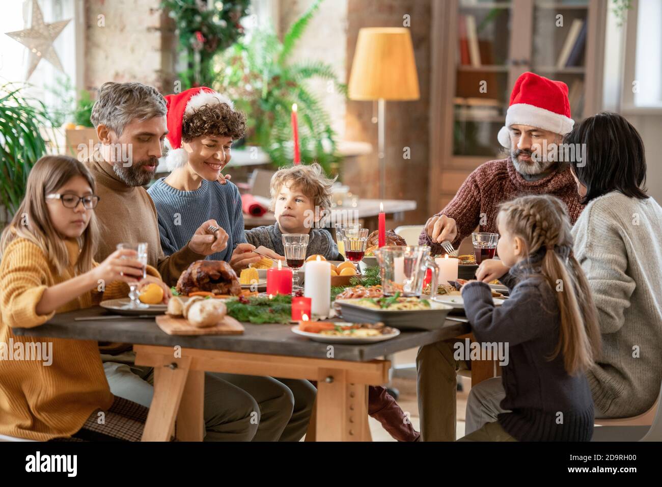 Contemporary large multi-generation family sitting by served festive table Stock Photo
