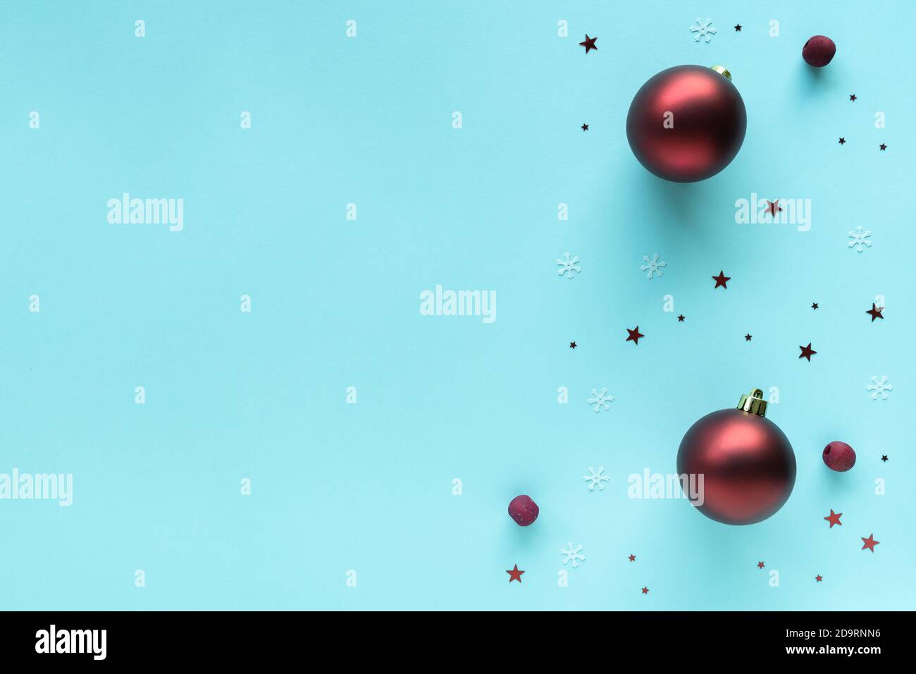 Christmas composition with red bright baubles decorations on pastel blue surface, top view, copy space. Merry Christmas and Happy Holidays greeting Stock Photo
