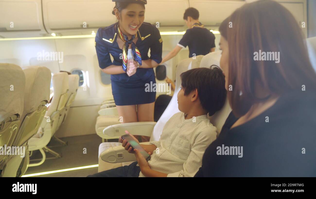 Cabin crew provide service to family in airplane . Airline