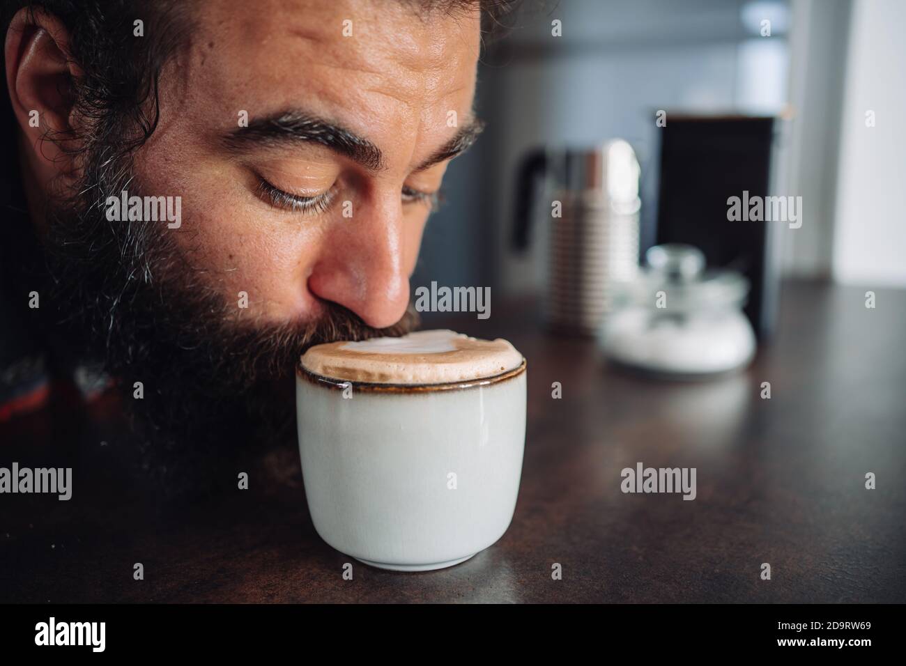 https://c8.alamy.com/comp/2D9RW69/detail-of-a-bearded-man-drinking-from-a-coffee-cup-with-some-milk-foam-2D9RW69.jpg