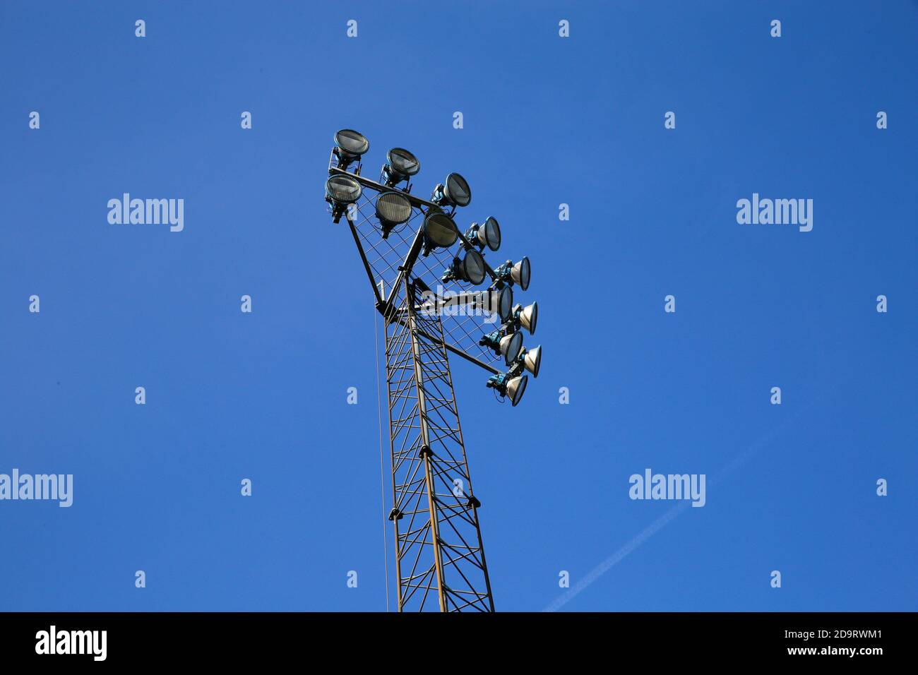 Low angel view on pole with floodlights against blue sky Stock Photo