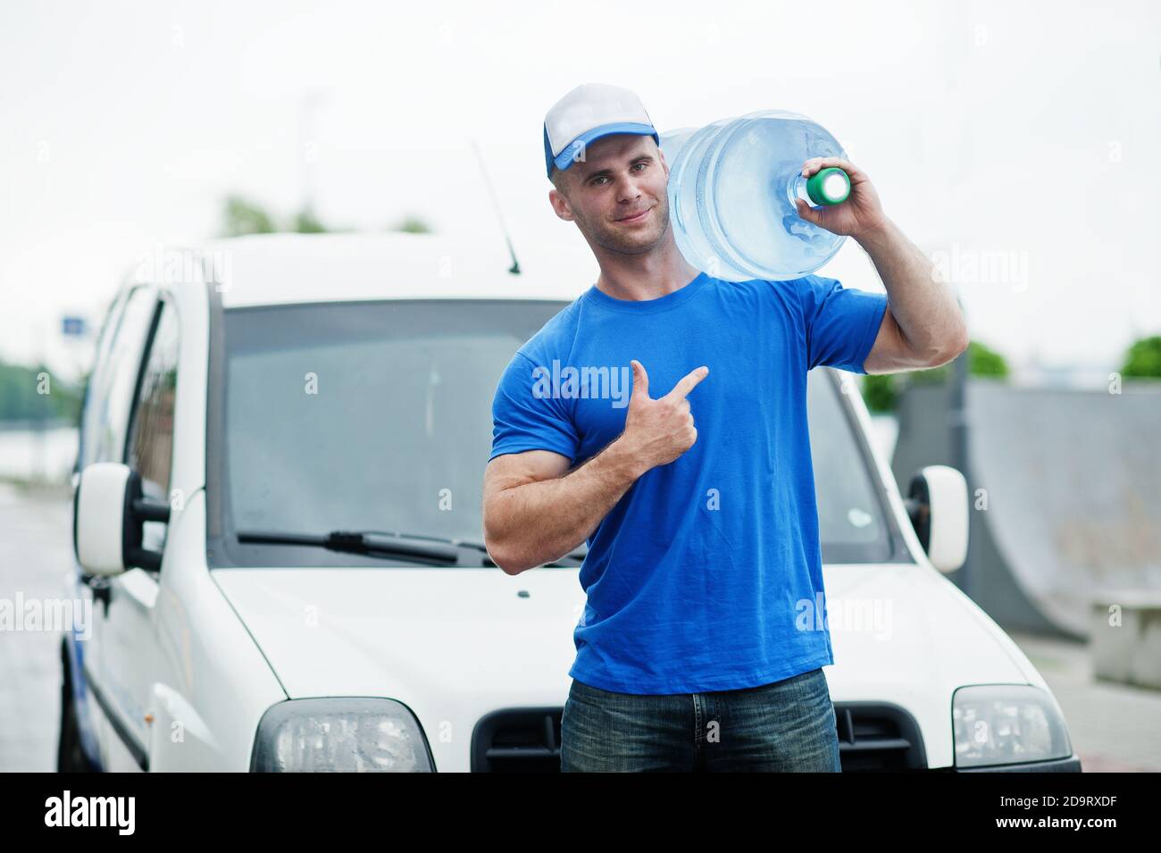 Delivery man in front cargo van delivering bottles of water showing ...