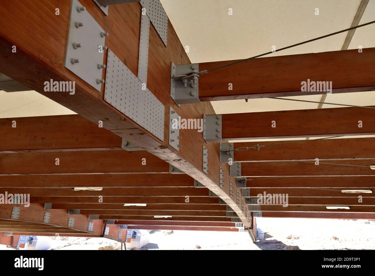 Heavy laminated structural timber beam with bolted hardware joints in roof covering site of “House of Eustolios”, Kourion Archaeological Site, Cyprus Stock Photo