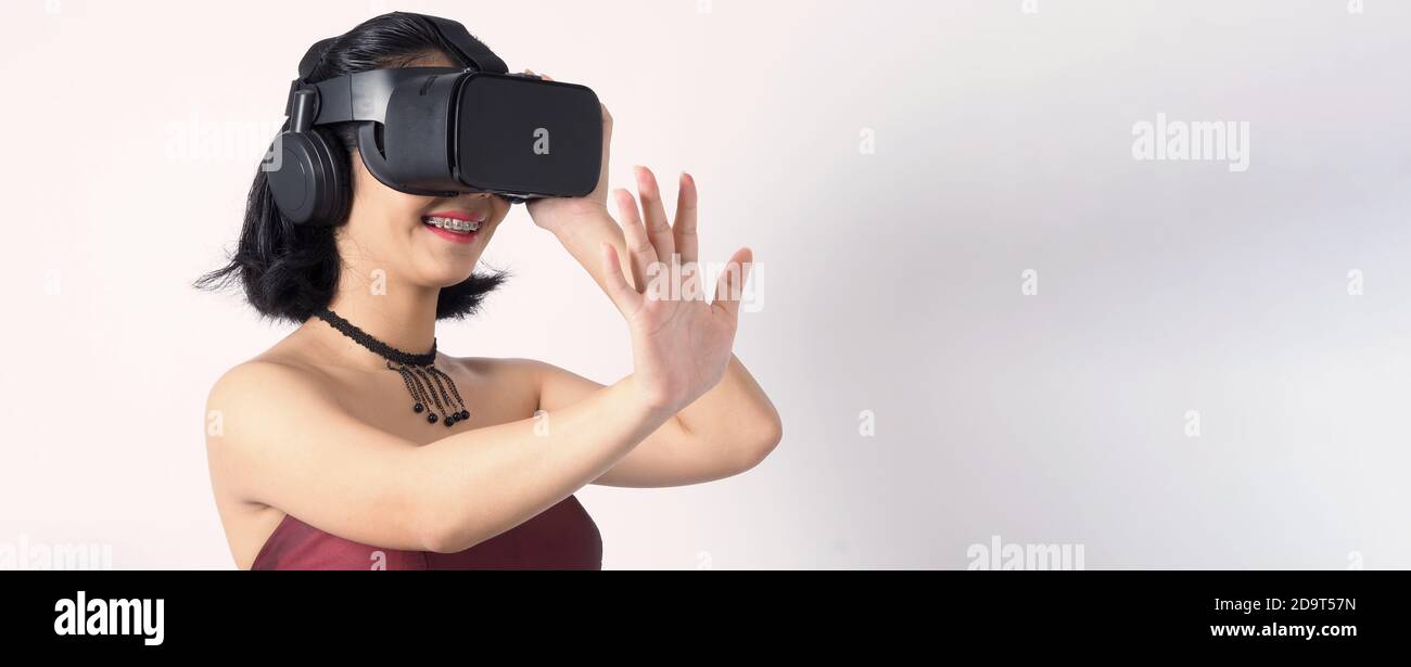 Asian teen woman wearing VR or Virtual Reality head set for enter to the  digital simulation world for learning and traveling or gaming and more. Stud  Stock Photo - Alamy