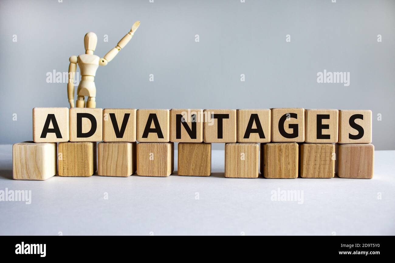 'Advantages' written on wood blocks. Business concept. Wooden model of human. Copy space. Beautiful white background. Stock Photo