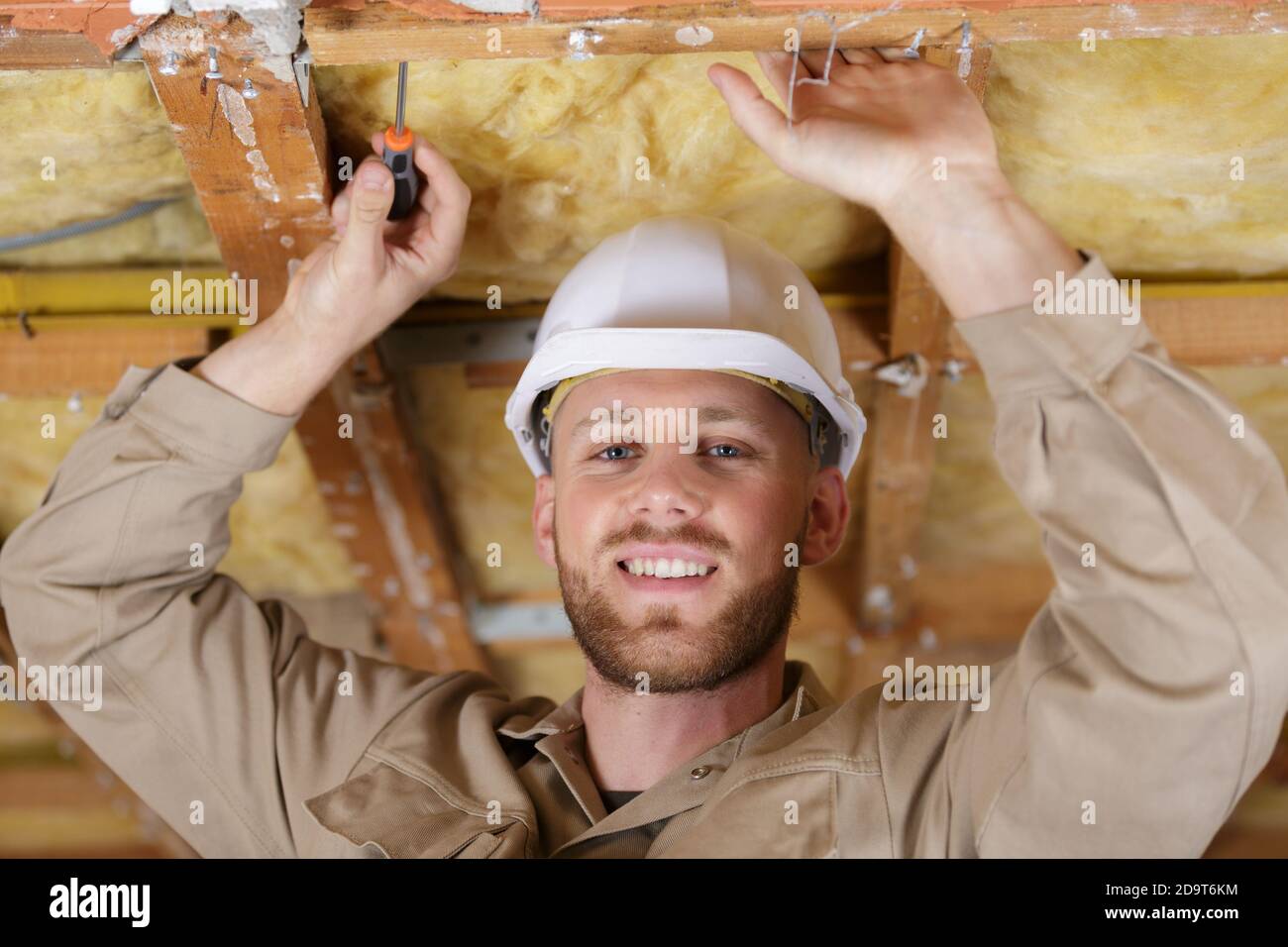 portrait of builder working on roof insulation Stock Photo Alamy