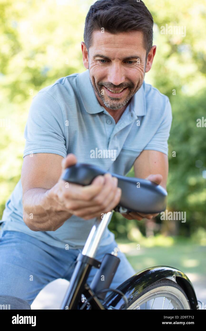 mature male cyclist adjusting bicycle seat Stock Photo Alamy