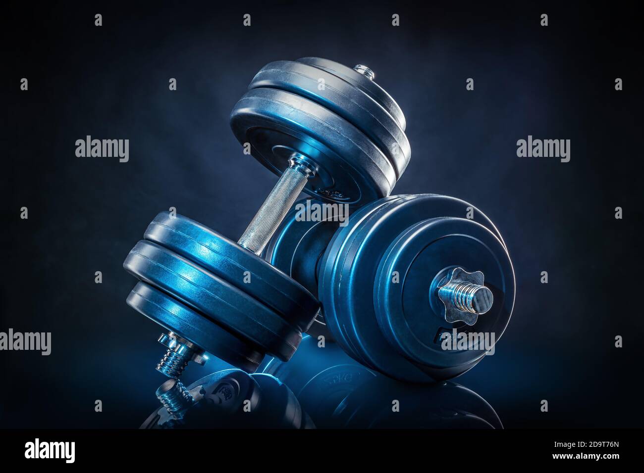 dumb bells against a black background Stock Photo