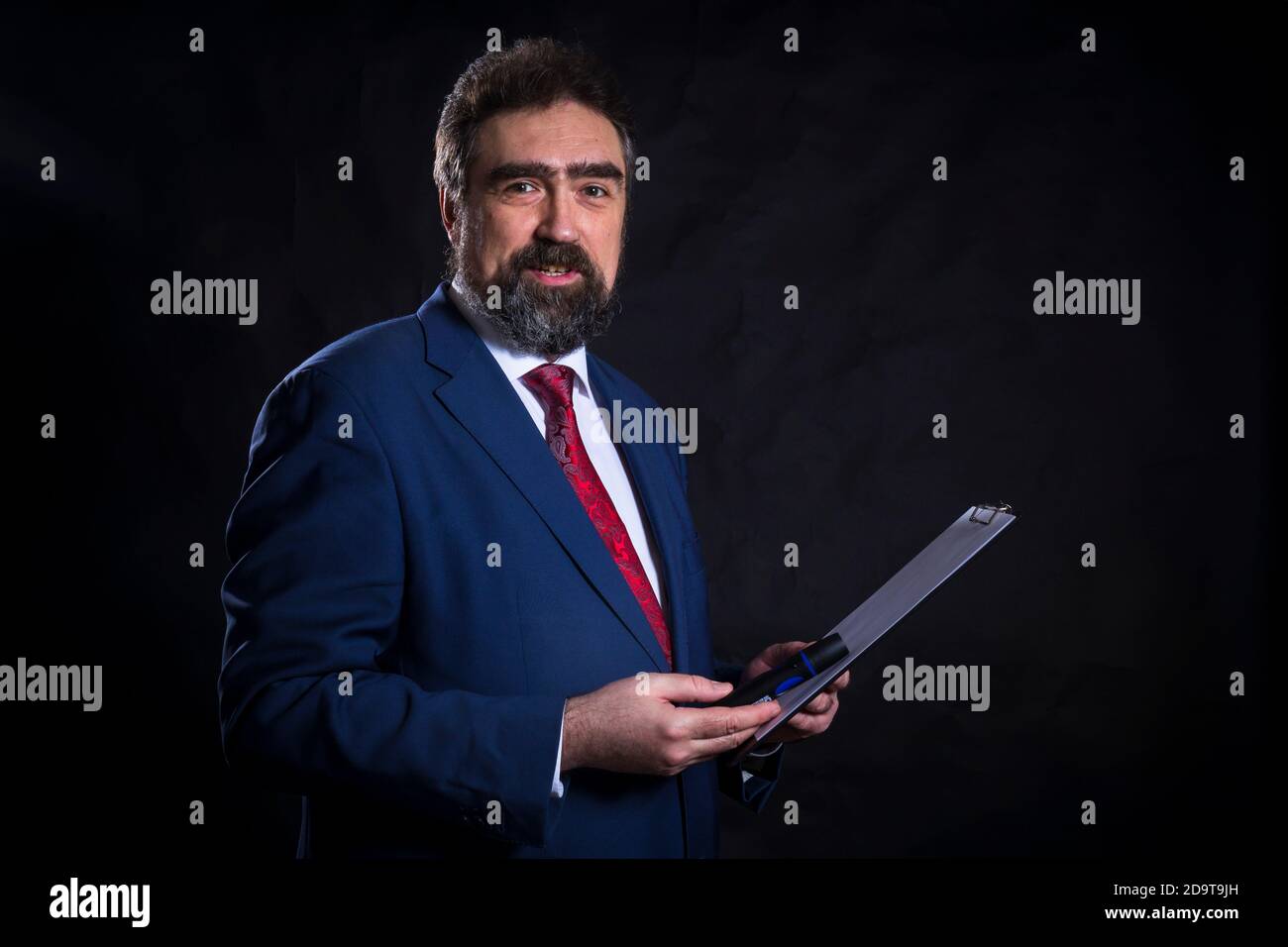 Mature businessman dressed in blue suit with red tie studio portrait ...
